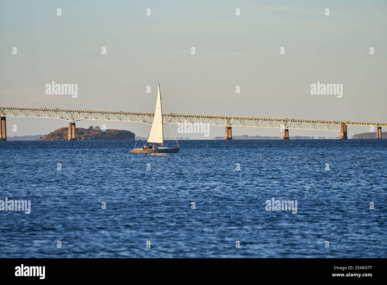Un voilier navigue devant le pont Claiborne Pell Newport dans une belle eau bleue de l'océan. Banque D'Images