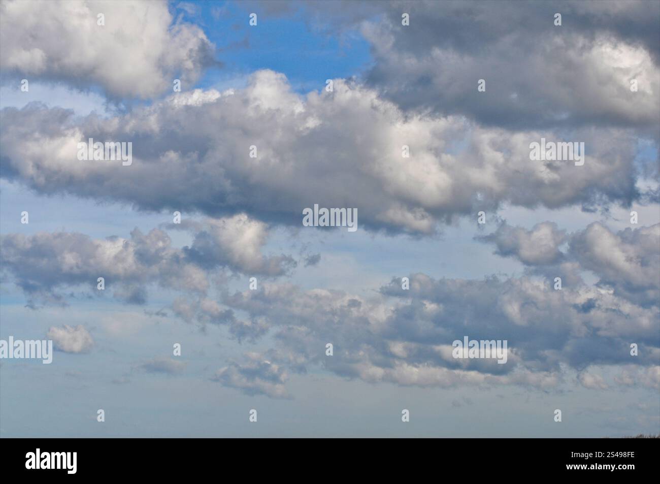 Grandes formations nuageuses avec des zones de ciel bleu entre elles, paysage nuageux de base avec ciel seulement. Banque D'Images