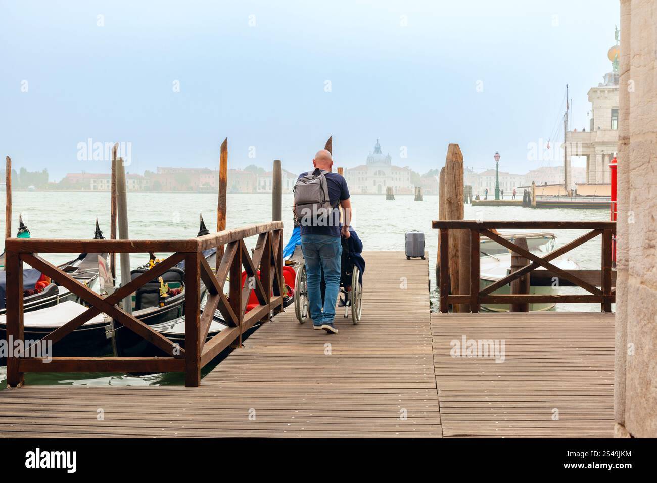 Un quai en bois avec des gondoles amarrées sur le côté, surplombant le lagon de Venise, Italie Banque D'Images