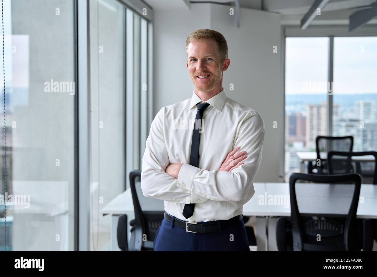 Souriant jeune homme d'affaires confiant regardant la caméra dans le bureau, portrait. Banque D'Images