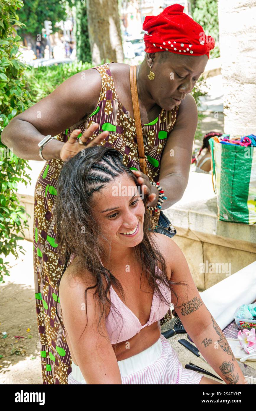 Palma de Majorque Îles Baléares Espagne, jardin Jardi de trames, femme africaine noire, client adolescent, style de tressage de cheveux, artisanat traditionnel Banque D'Images Palma de Majorque Îles Baléares Espagne, jardin Jardi de trames, femme africaine noire, client adolescent, style de tressage de cheveux, artisanat traditionnel Banque D'Images