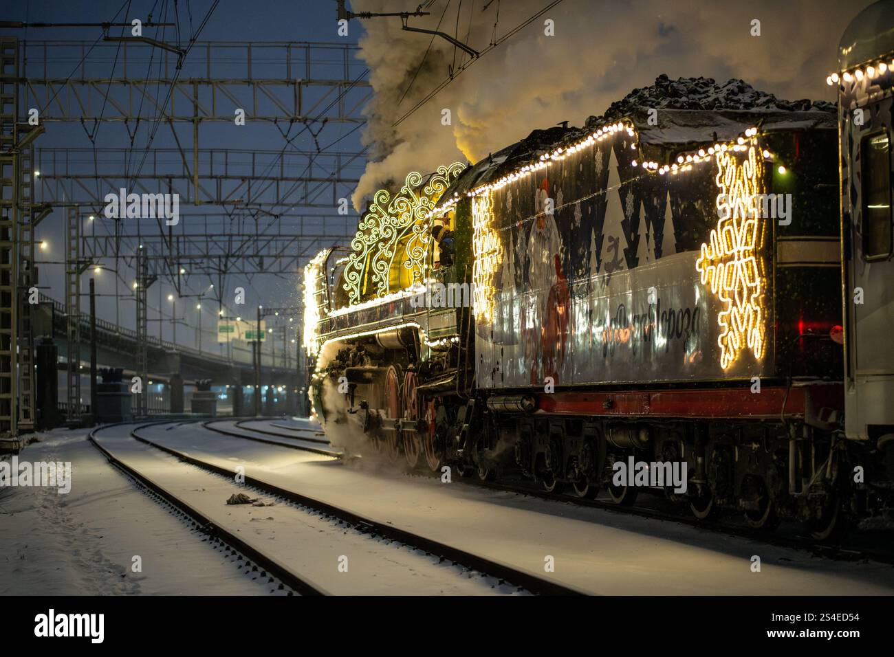 Train à vapeur rétro de Noël la nuit dans la ville la veille de Noël et le nouvel an en Russie. Banque D'Images