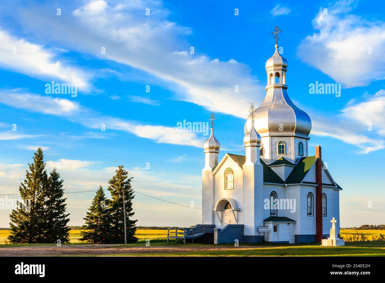 Une grande église blanche avec une croix sur le toit. Le ciel est bleu et il y a quelques nuages Banque D'Images