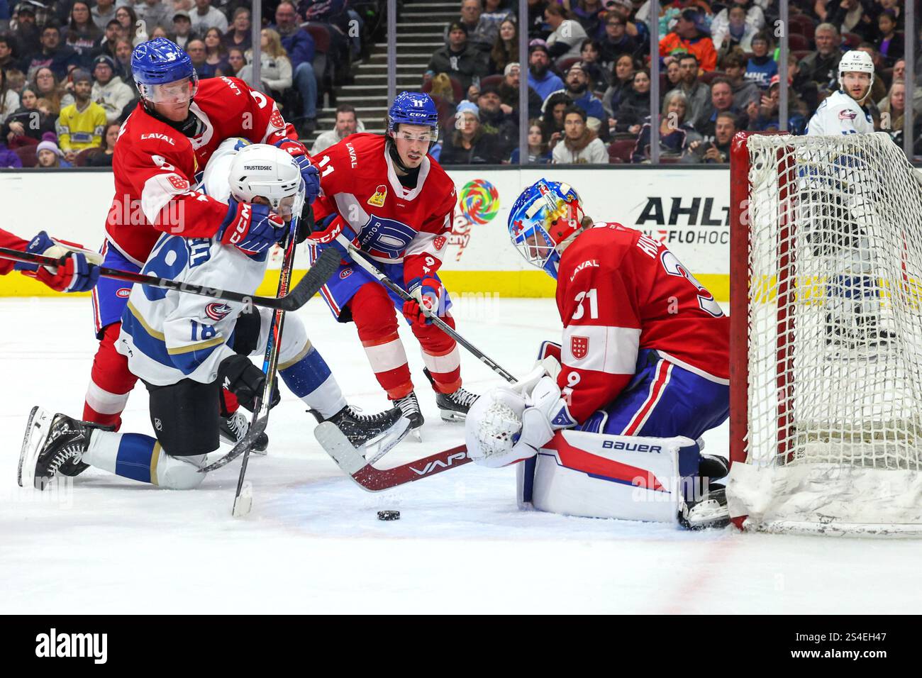 CLEVELAND, OH - JANUARY 11: Laval Rocket defenseman Gustav Lindstrom (5) tackles Cleveland Monsters center Dylan Gambrell (18) as the puck is loose in front of Laval Rocket goaltender Connor Hughes (31) during the second period of the American Hockey League game between the Laval Rocket and Cleveland Monsters on January 11, 2025, at Rocket Mortgage FieldHouse in Cleveland, OH. (Photo by Frank Jansky/Icon Sportswire) (Icon Sportswire via AP Images) Banque D'Images