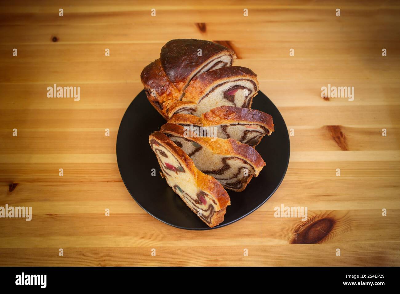 Cozonac, pain sucré traditionnel roumain avec garniture de noix, tranché, plat posé sur une table en bois Banque D'Images