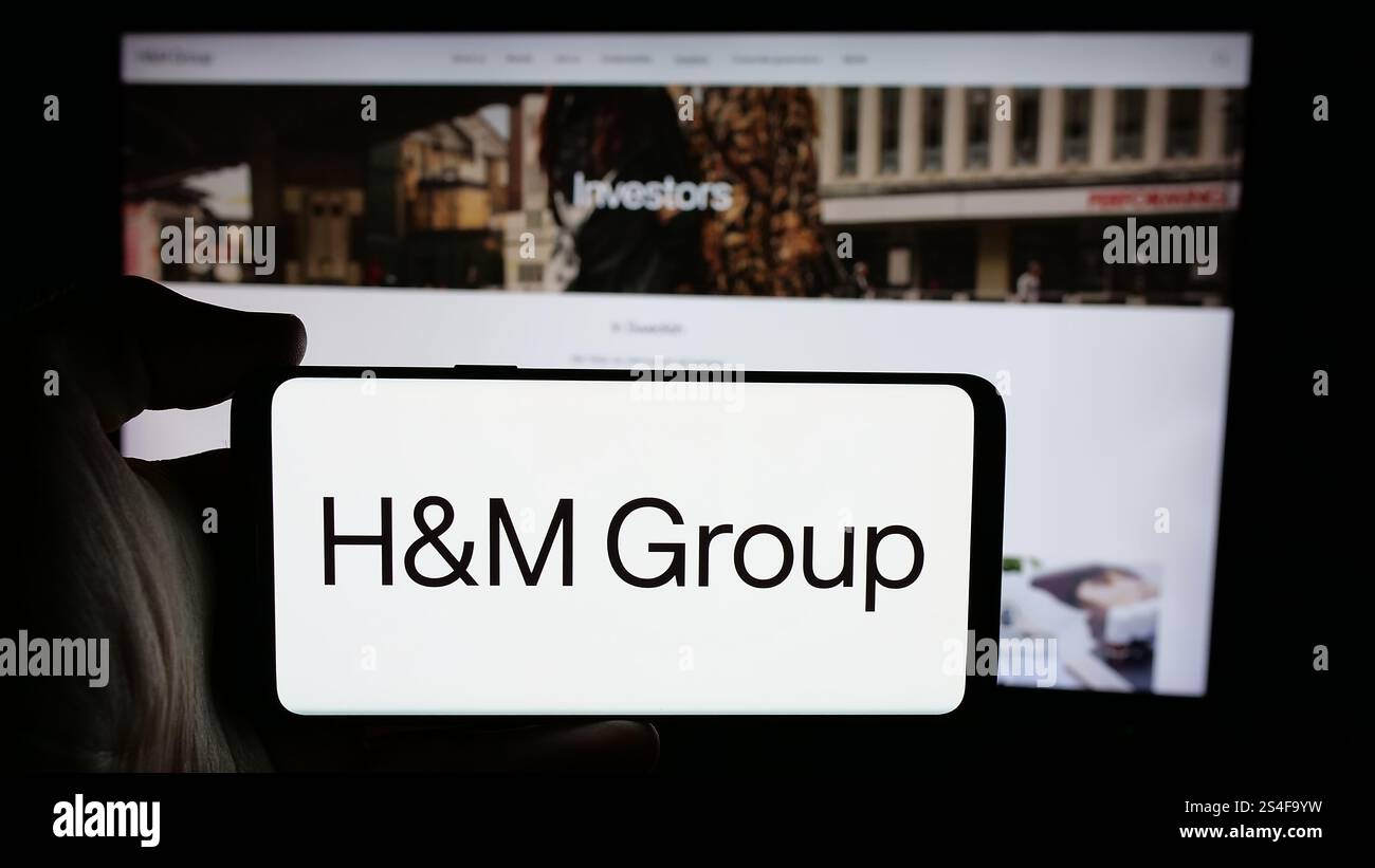 Allemagne. 14 octobre 2024. Dans cette illustration photo, une personne tient un téléphone portable avec le logo de l'entreprise de mode suédoise H M Hennes Mauritz AB sur l'écran devant la page Web. (Crédit image : © timon Schneider/SOPA images via ZUMA Press Wire) USAGE ÉDITORIAL SEULEMENT ! Non destiné à UN USAGE commercial ! Banque D'Images