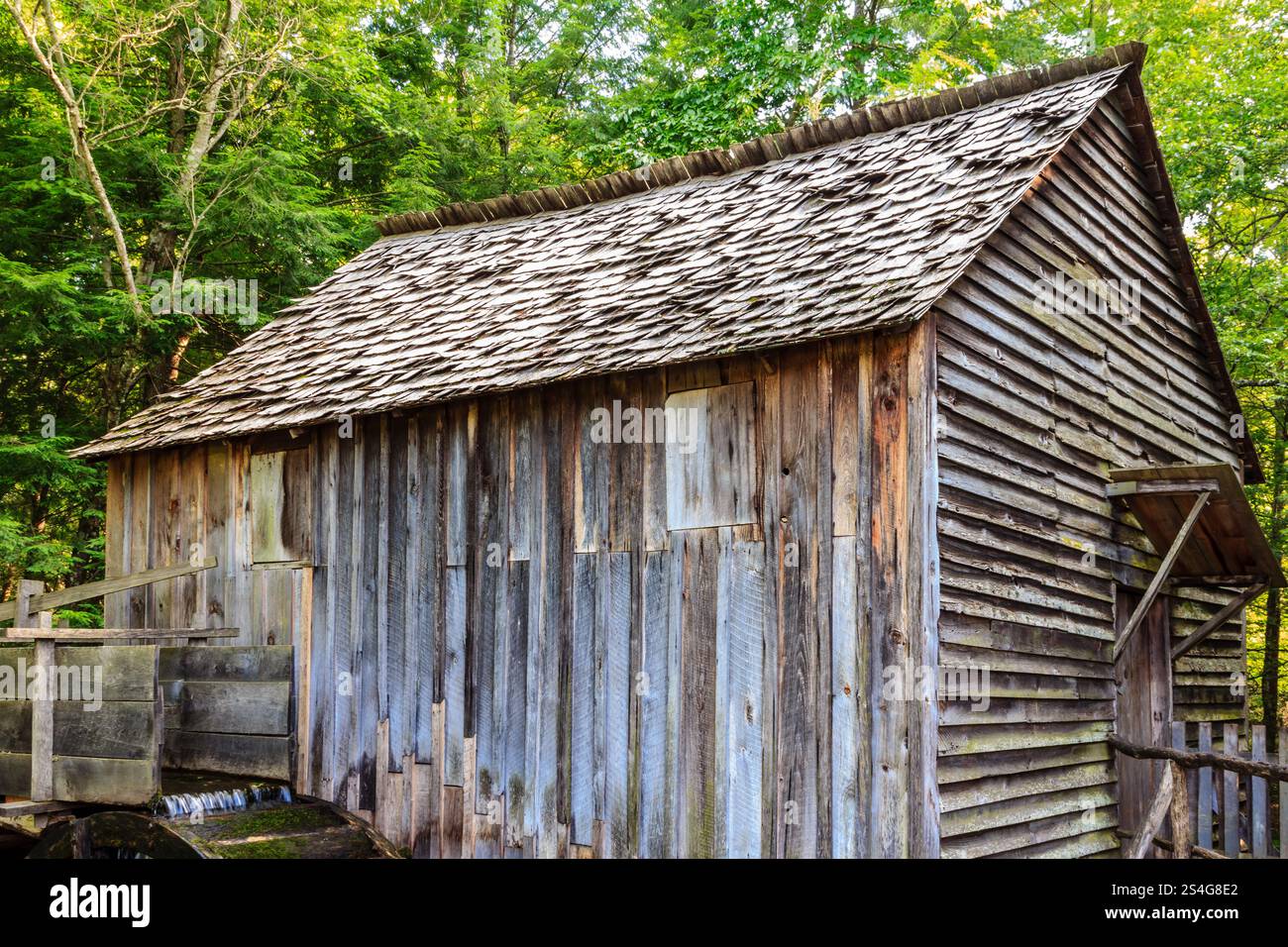 Un grand bâtiment ancien en bois avec un toit incliné. Le toit est recouvert de bardeaux Banque D'Images