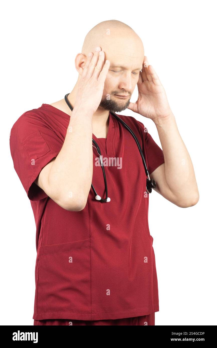 Un médecin chauve avec une barbe, vêtu de gommages rouges et portant un stéthoscope autour du cou, tient la tête des deux mains et ferme la sienne Banque D'Images
