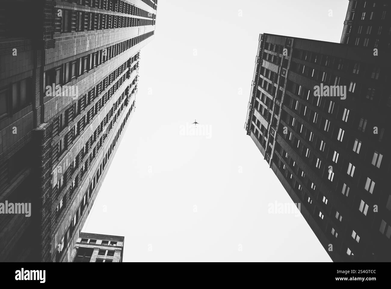 Perspective en noir et blanc de gratte-ciel avec avion au-dessus Banque D'Images
