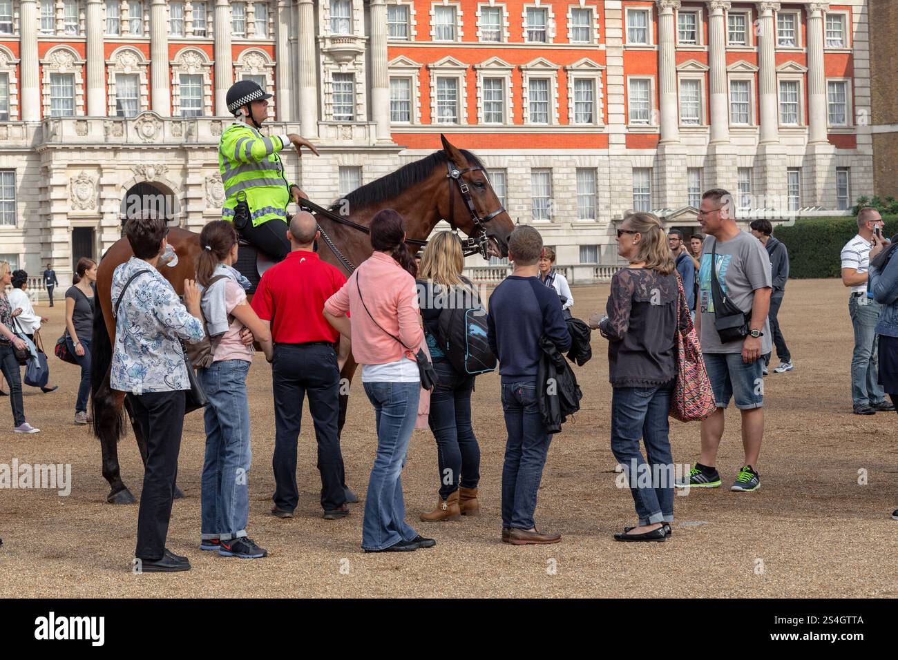 LONDRES, GRANDE-BRETAGNE - 19 SEPTEMBRE 2014 : des touristes non identifiés écoutent les instructions d'un policier monté avant qu'un garde monté ne soit déplo Banque D'Images