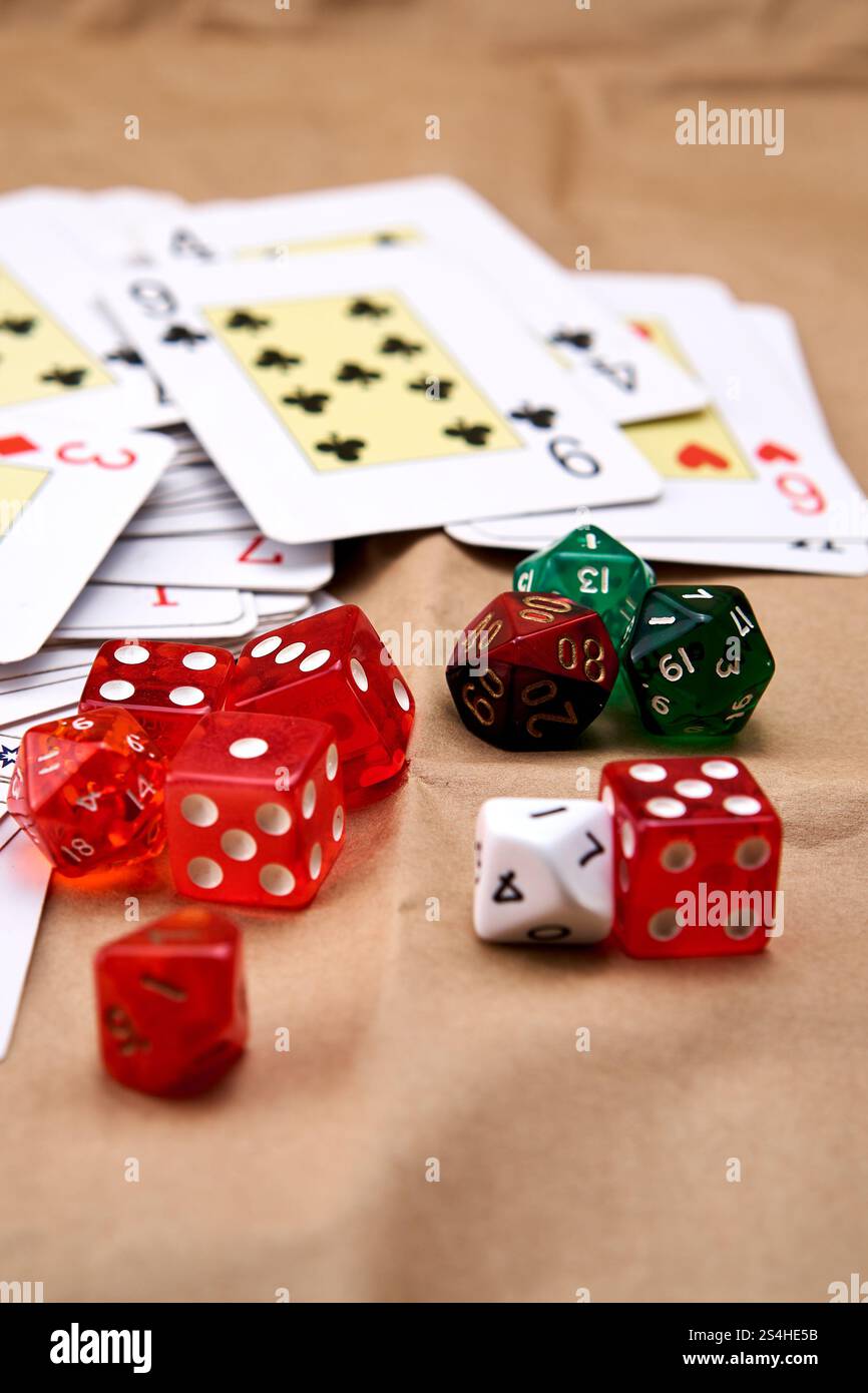 Un jeu de cartes de poker se déploie sur une table et une pile de dés. Banque D'Images