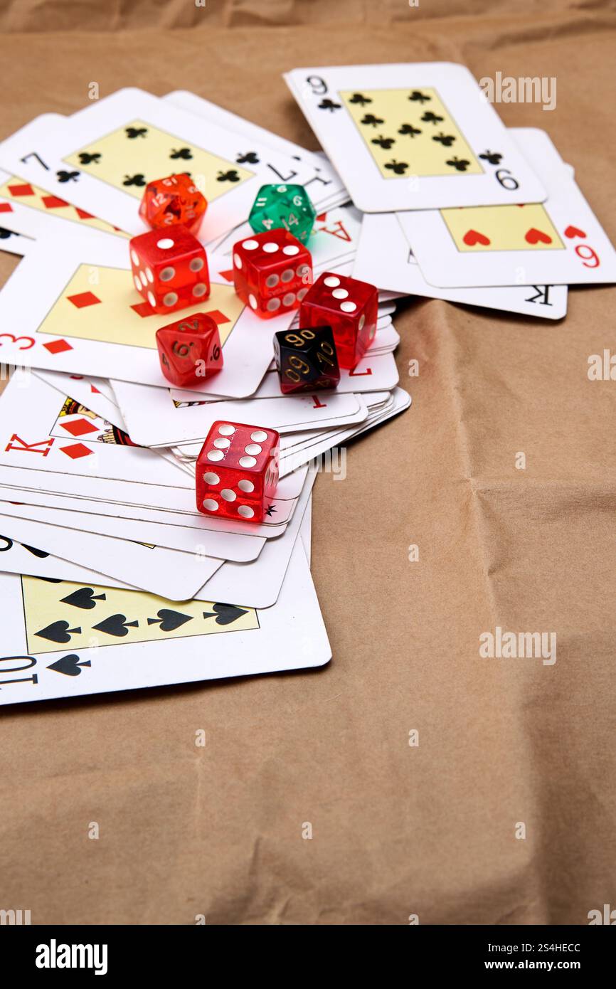 Un jeu de cartes de poker se déploie sur une table et une pile de dés. Banque D'Images