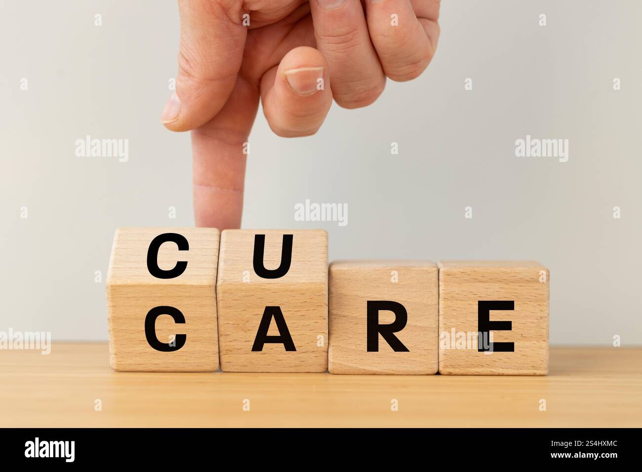 Symbol Care and Cure. La main tourne le bloc de bois et change le mot SOIN à GUÉRIR. Banque D'Images