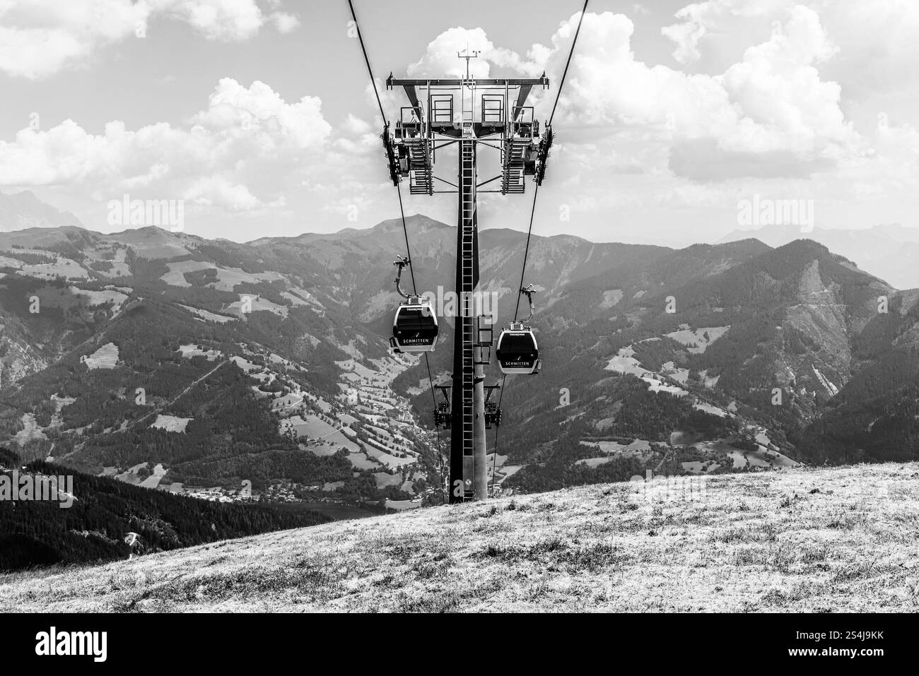 Le téléphérique monte sur les pentes de Schmittenhohe, offrant une vue imprenable sur les Alpes autrichiennes environnantes et les vallées verdoyantes, mettant en valeur la beauté de la nature en été. Banque D'Images