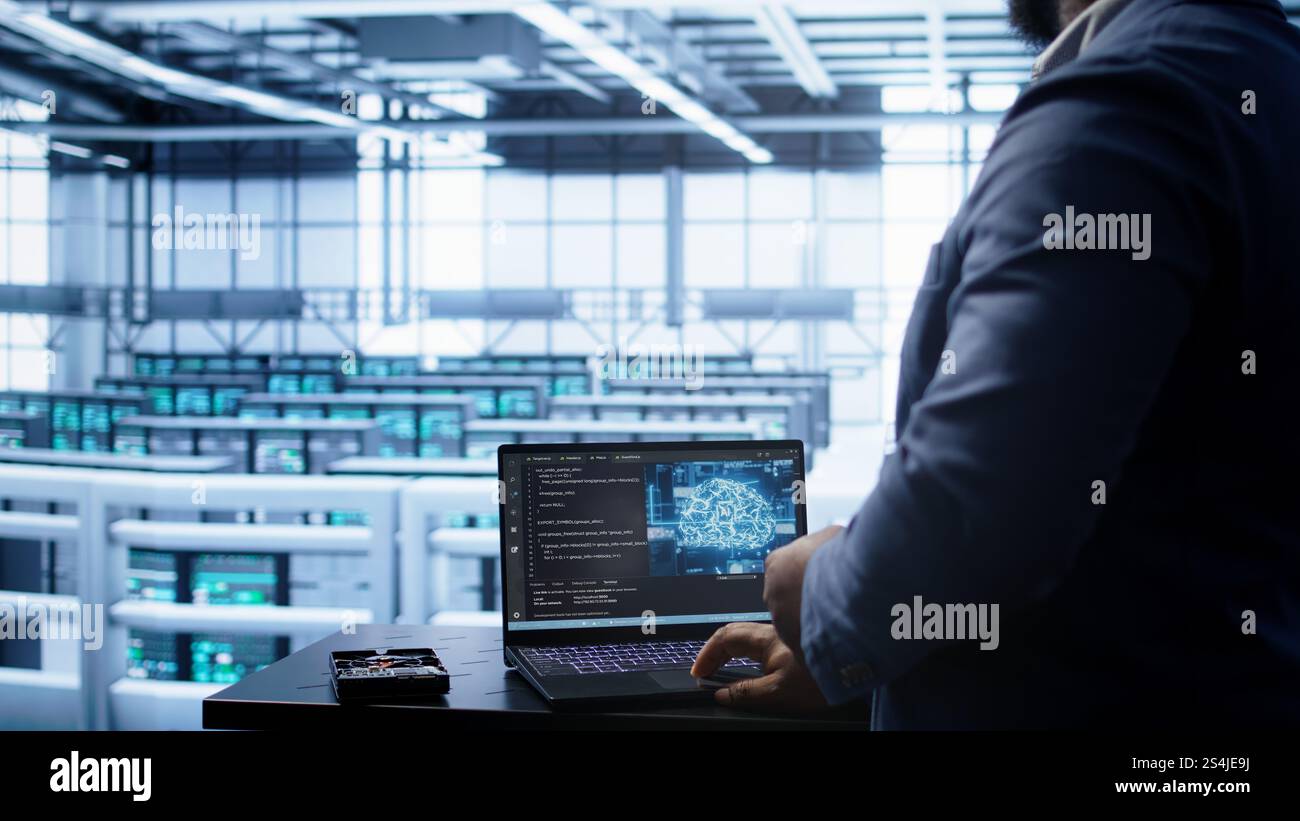 Développeur de logiciels dans un centre de données utilisant l'informatique d'intelligence artificielle simulant le cerveau humain. Membre du personnel de soutien INFORMATIQUE travaillant sur ordinateur portable avec des algorithmes d'apprentissage automatique ai, caméra B. Banque D'Images