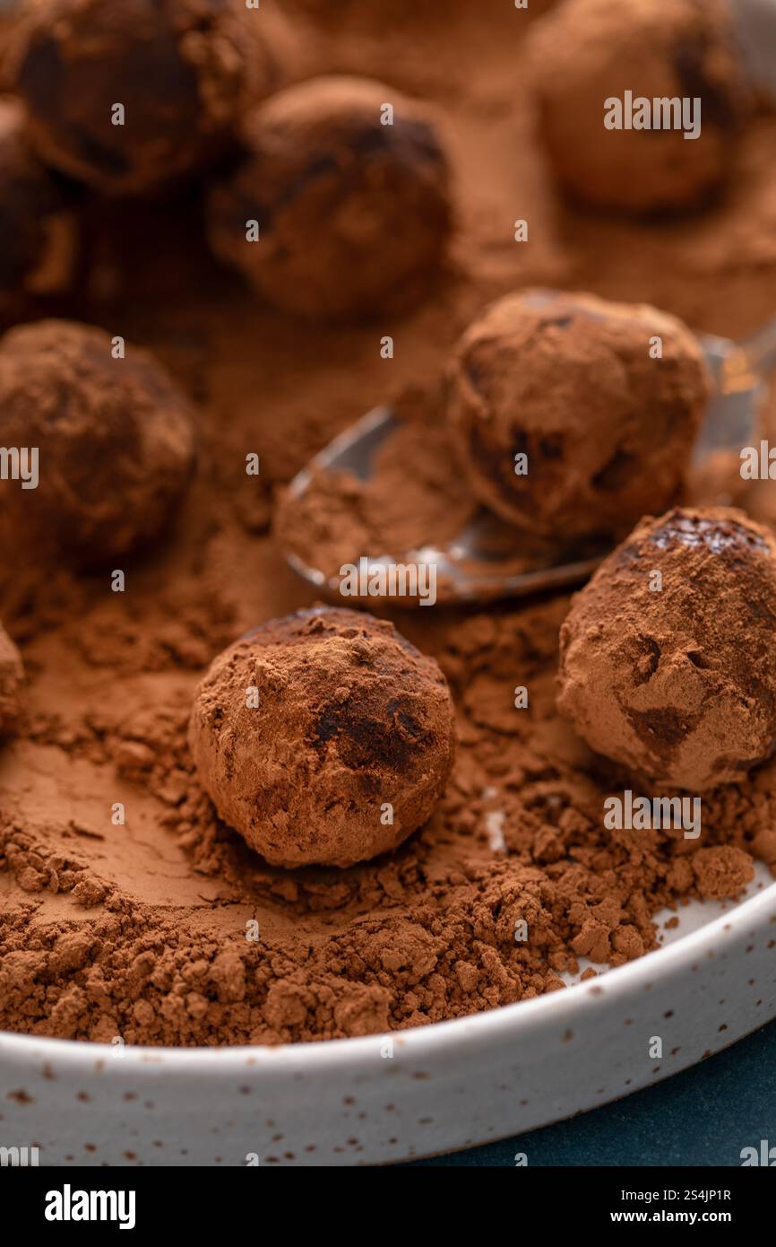 Truffes au chocolat artisanales maison saupoudrées de poudre de cacao sur une assiette avec une cuillère Banque D'Images