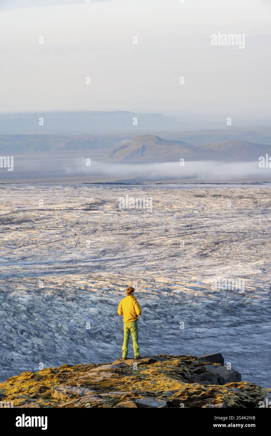Jeune homme, touriste devant un glacier impressionnant, dans la lumière du soir, langues du glacier Koetlujoekull, glacier Myrdalsjoekull Pakgil, Islande, Europe Banque D'Images