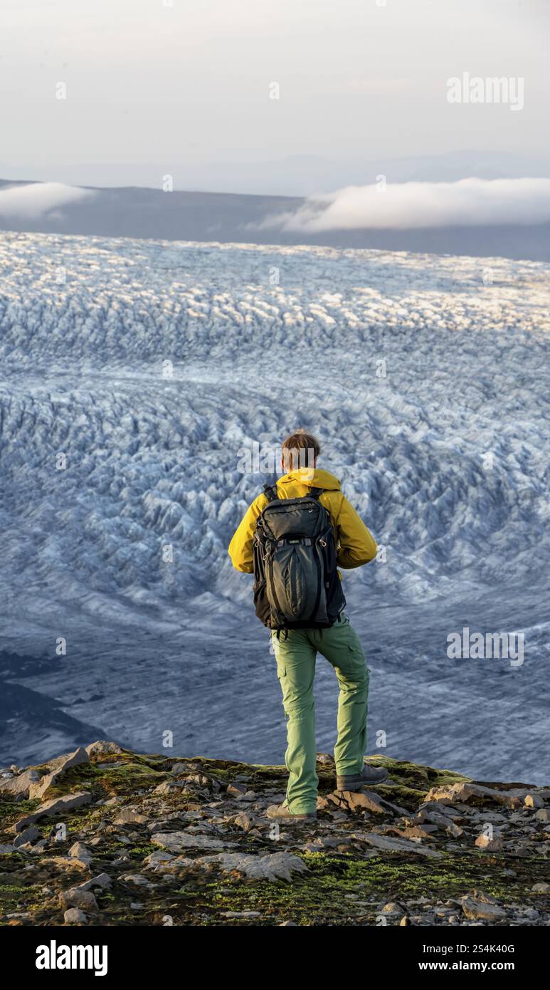 Jeune homme, touriste devant un glacier impressionnant, dans la lumière du soir, langues du glacier Koetlujoekull, glacier Myrdalsjoekull Pakgil, Islande, Europe Banque D'Images