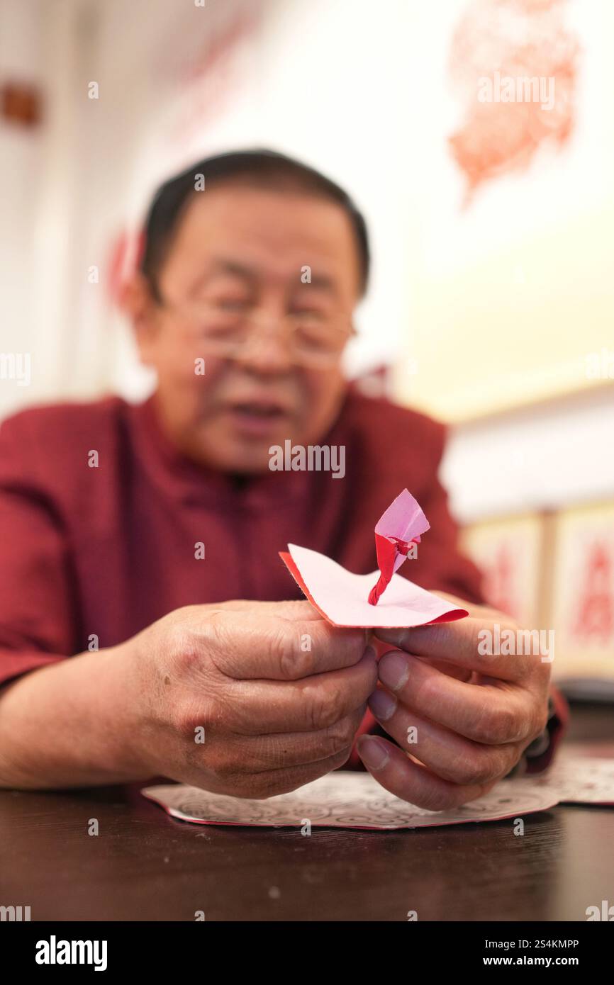 Zhang Xiaolin montre l'habileté de la coupe de papier. Beijing, Chine.10th janvier 2025. Zhang Xiaolin est un héritier de l'art de la coupe de papier de Pékin, une sorte de patrimoine culturel immatériel chinois. Alors que le nouvel an lunaire chinois approche, les œuvres de Zhang sont populaires auprès des gens. Crédit : Zhang Xiangyi/China News Service/Alamy Live News Banque D'Images Zhang Xiaolin montre l'habileté de la coupe de papier. Beijing, Chine.10th janvier 2025. Zhang Xiaolin est un héritier de l'art de la coupe de papier de Pékin, une sorte de patrimoine culturel immatériel chinois. Alors que le nouvel an lunaire chinois approche, les œuvres de Zhang sont populaires auprès des gens. Crédit : Zhang Xiangyi/China News Service/Alamy Live News Banque D'Images