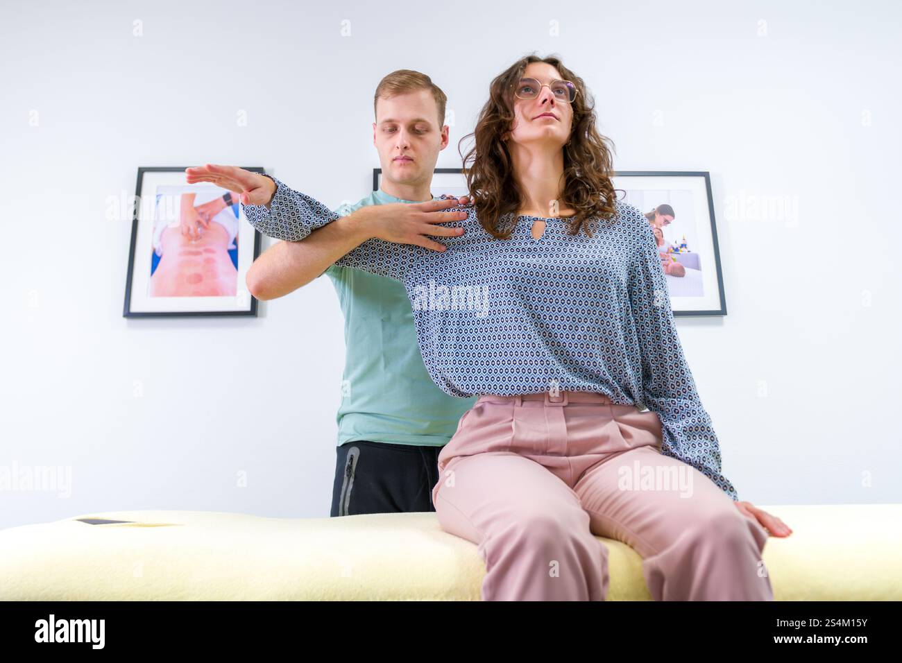 Femme avec douleur à l'épaule en thérapie physique. Chiropraticien examinant les traumatisés articulaires de l'épaule. Banque D'Images