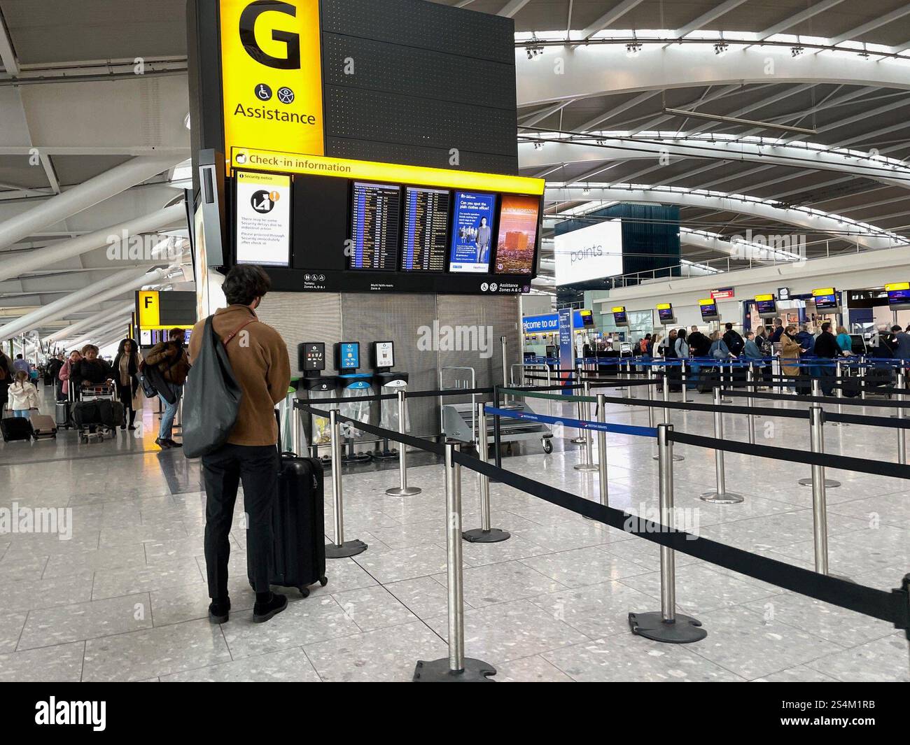 Photo du dossier datée du 31/03/23 de passagers faisant la queue pour s'enregistrer au terminal 5 de l'aéroport d'Heathrow, Londres. L'aéroport d'Heathrow a déclaré que 2024 a été son année la plus occupée pour le nombre de passagers, signalant que quelque 83,9 millions de passagers ont voyagé à travers les terminaux de l'aéroport ouest de Londres l'année dernière. C'est 4,7 millions de plus qu'en 2023 et 3,0 millions de plus que le précédent record annuel, établi en 2019. Date d'émission : lundi 13 janvier 2025. Banque D'Images