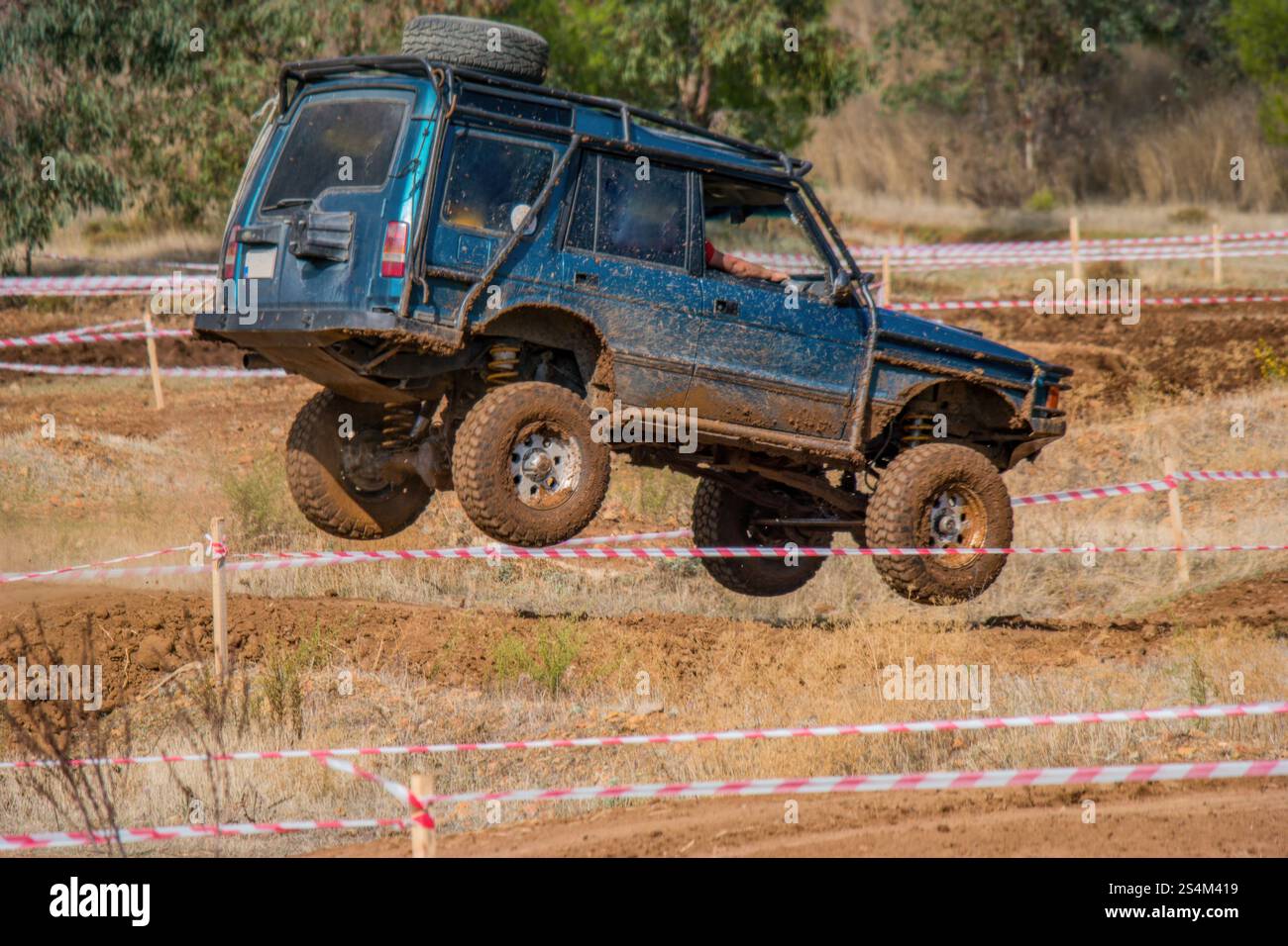 sensations fortes des courses tout-terrain. Un SUV modifié est capturé en plein air, survolant un saut de terre. Banque D'Images