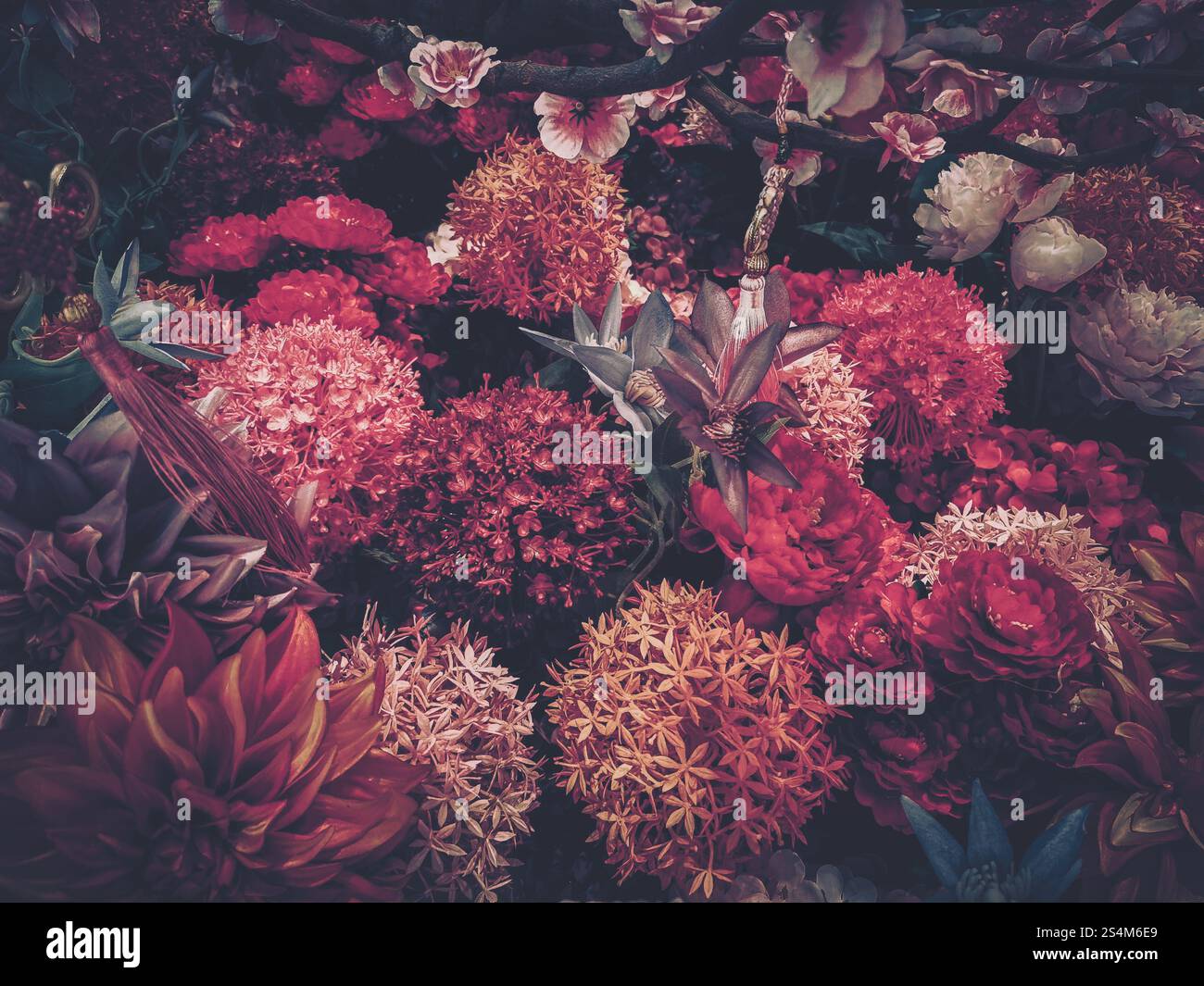 Image de style vintage mettant en vedette une profusion de fleurs artificielles dans des teintes riches et sombres, rappelant une célébration du nouvel an chinois. Banque D'Images