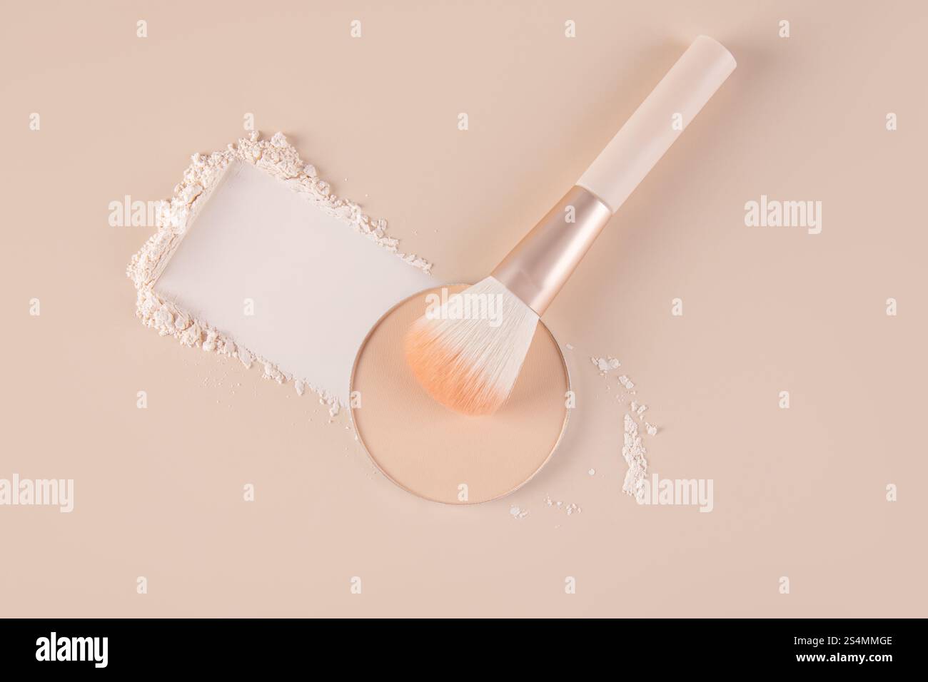 Vue de dessus d'un réglage de maquillage affichant un compact avec de la poudre pour le visage lâche à côté, dispersé doucement autour d'un pinceau doux sur un fond pastel. Banque D'Images