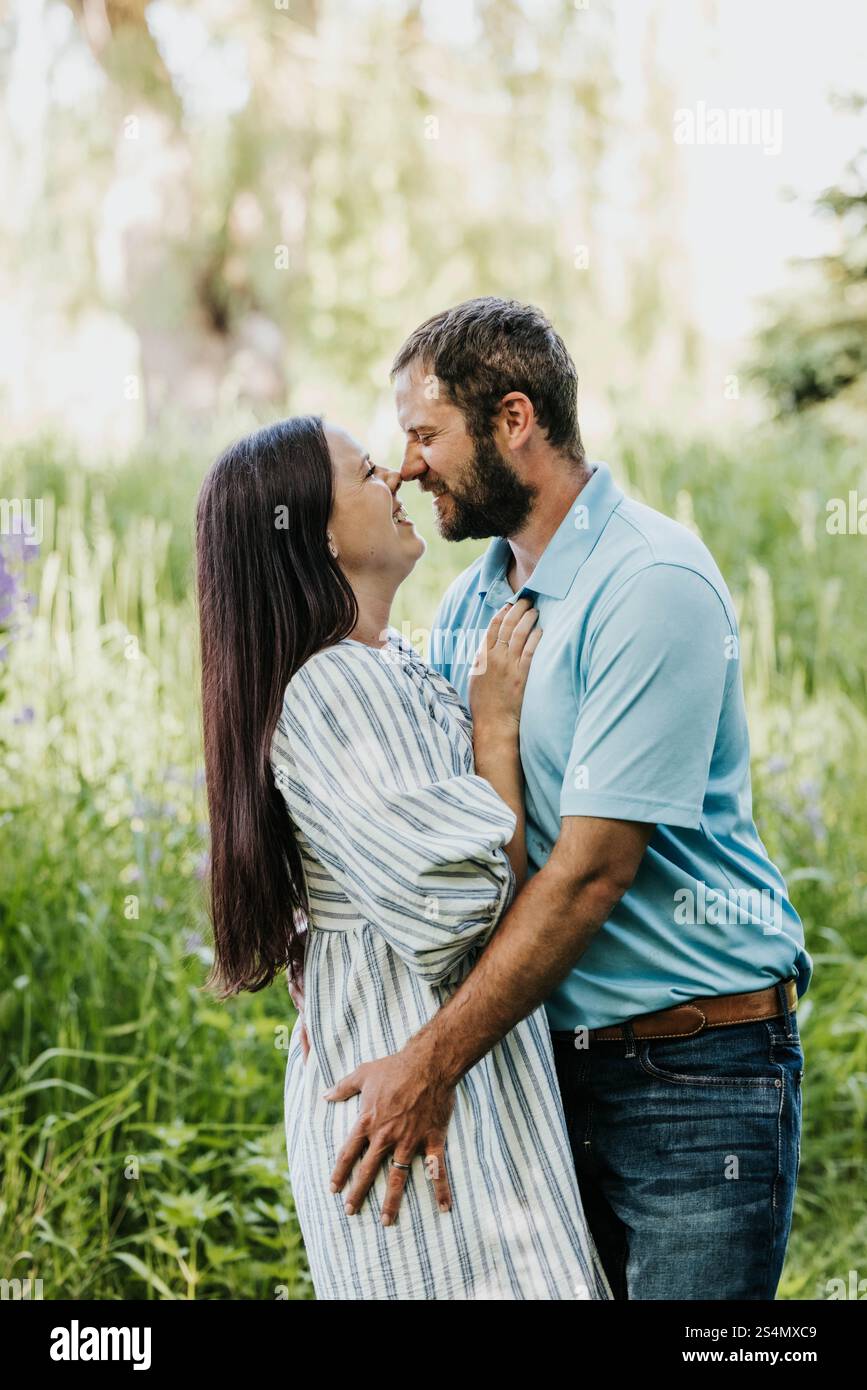 Homme et femme se tiennent l'un l'autre près de l'extérieur tout en souriant Banque D'Images