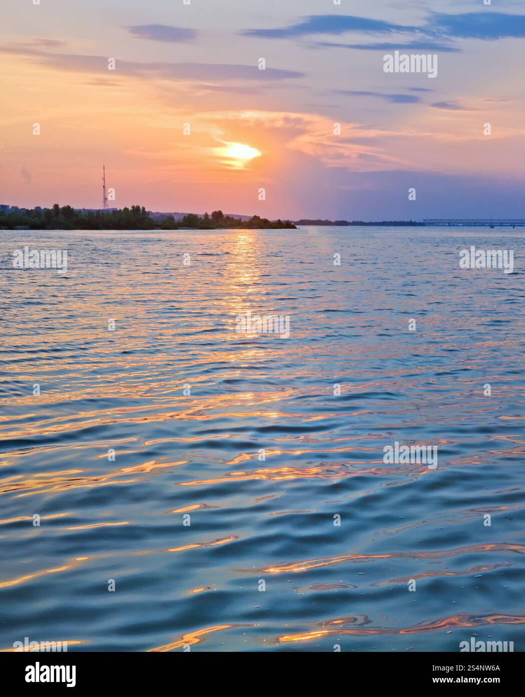 Vue sur le coucher du soleil sur la rivière avec chemin de lumière du soleil. Trois prises de vue assemblent l'image. Banque D'Images