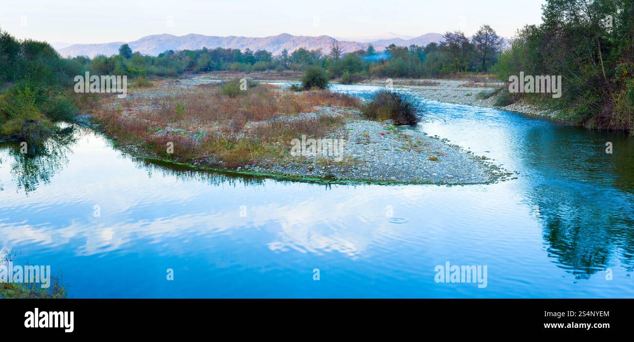 Panorama de la rivière bleue et montagne du soir d'automne derrière. Quatre prises de vue assemblent l'image. Banque D'Images