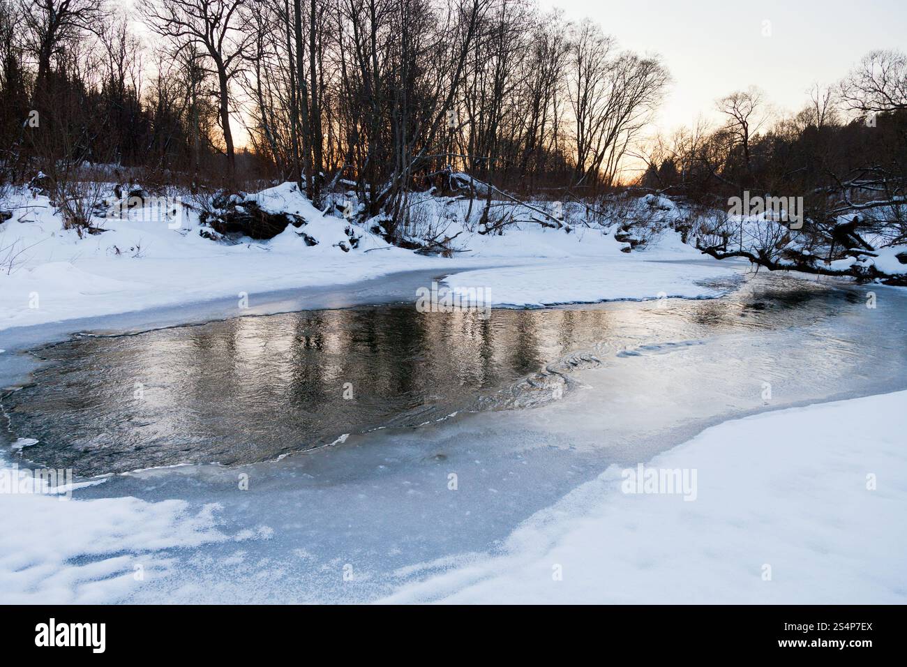 Berges de la neige au soleil d'hiver forêt stream Banque D'Images