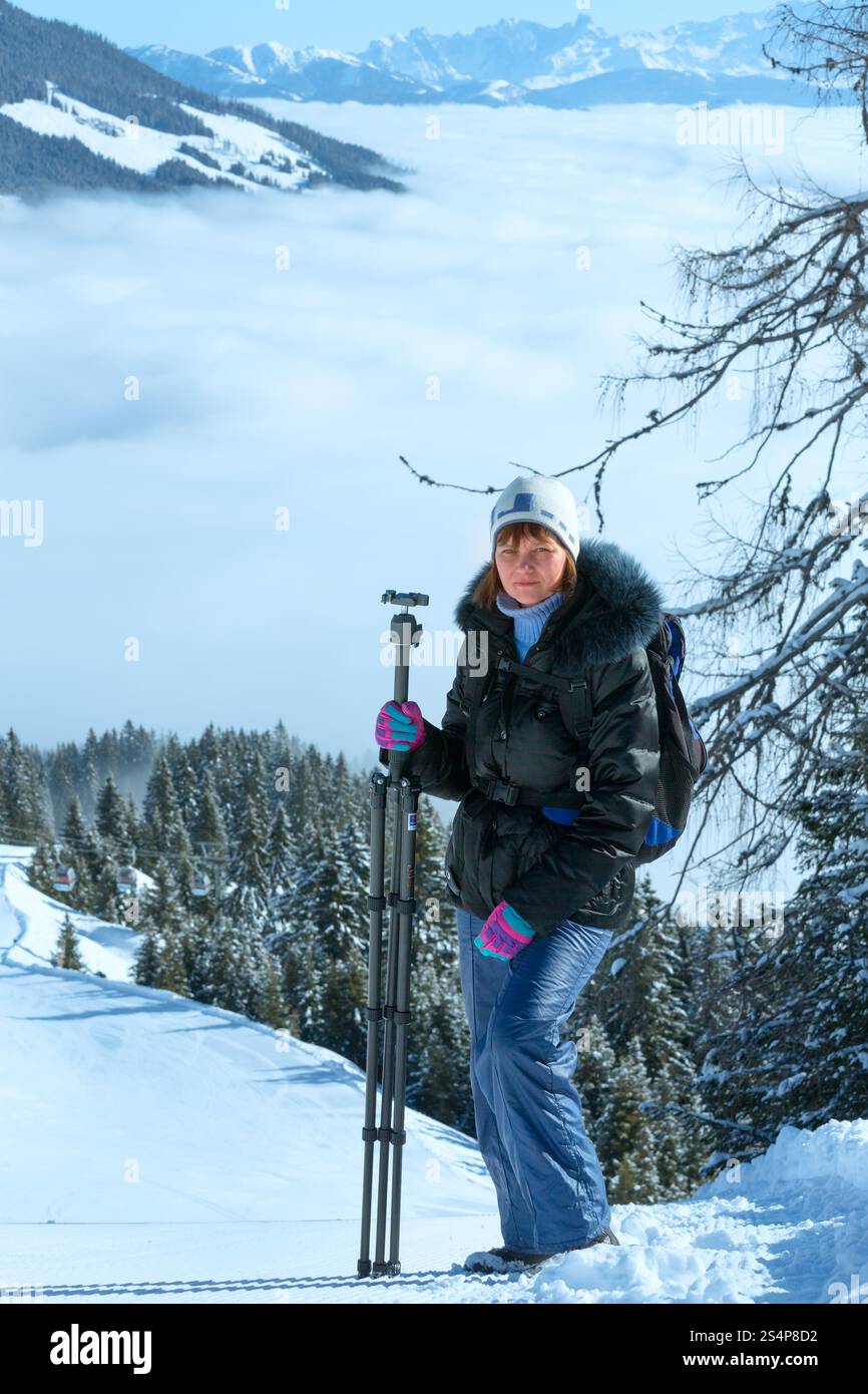Femme photographe - paysage de montagne d'hiver et matin avec les nuages dans la vallée ci-dessous (Hochkoenig région, Autriche) Banque D'Images