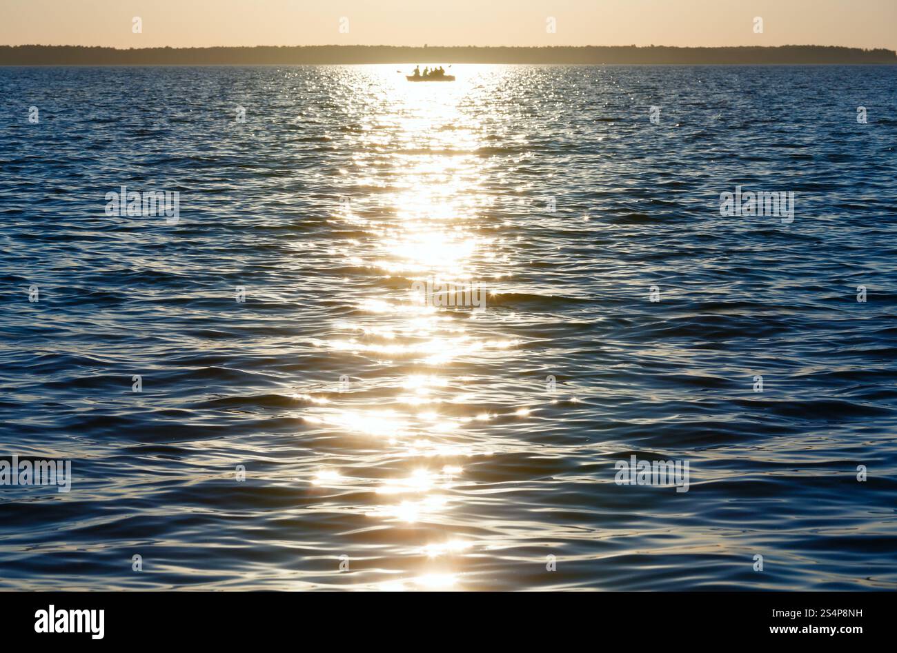 Coucher de soleil, la voie et la pêche bateau sur la surface du lac d'été. Banque D'Images