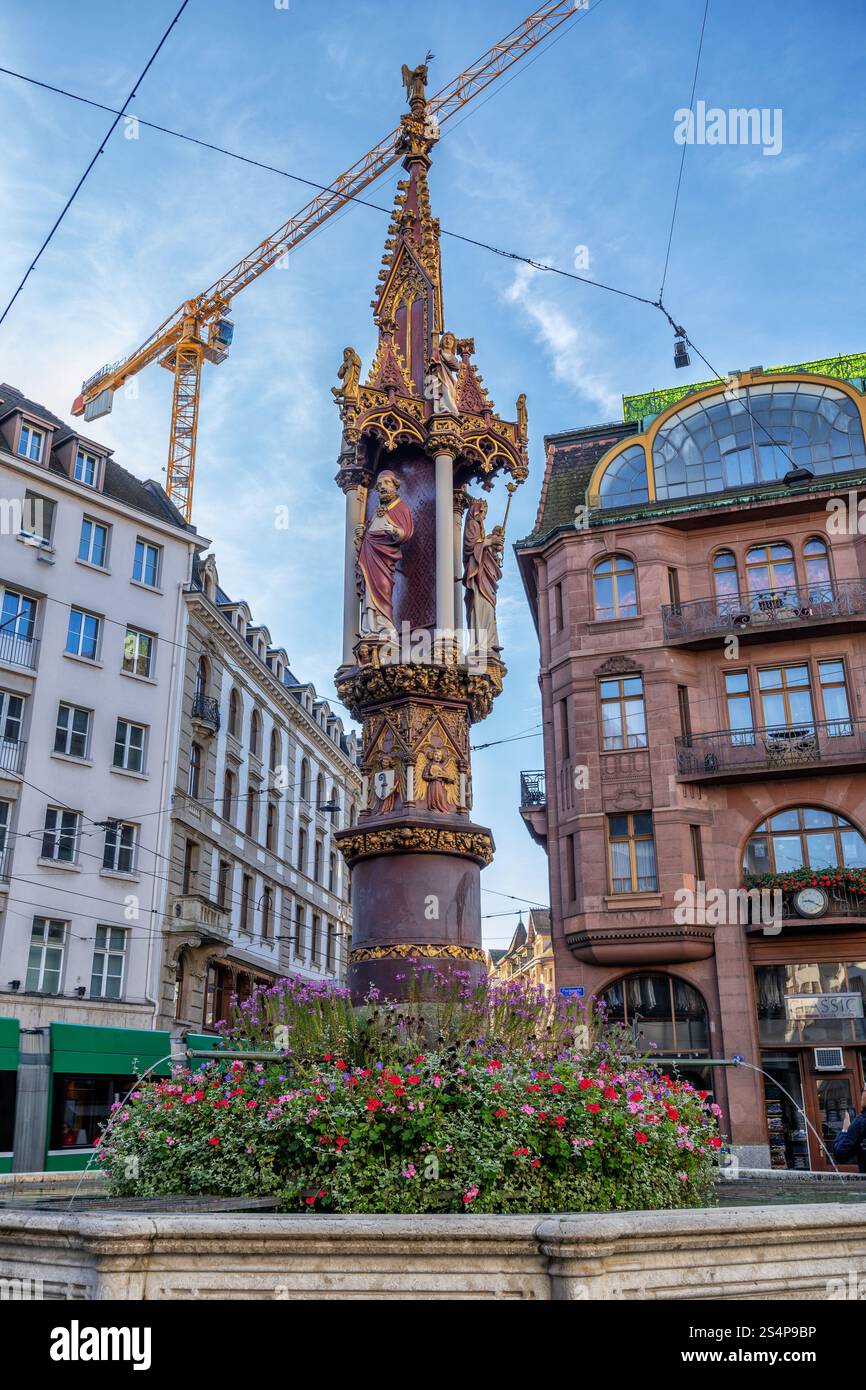 Fischmarktbrunnen - fontaine du marché aux poissons dans la ville de Bâle, Suisse. Fontaine gothique de 1380, colonne centrale avec des figures de Vierge Marie, équipée Pet Banque D'Images