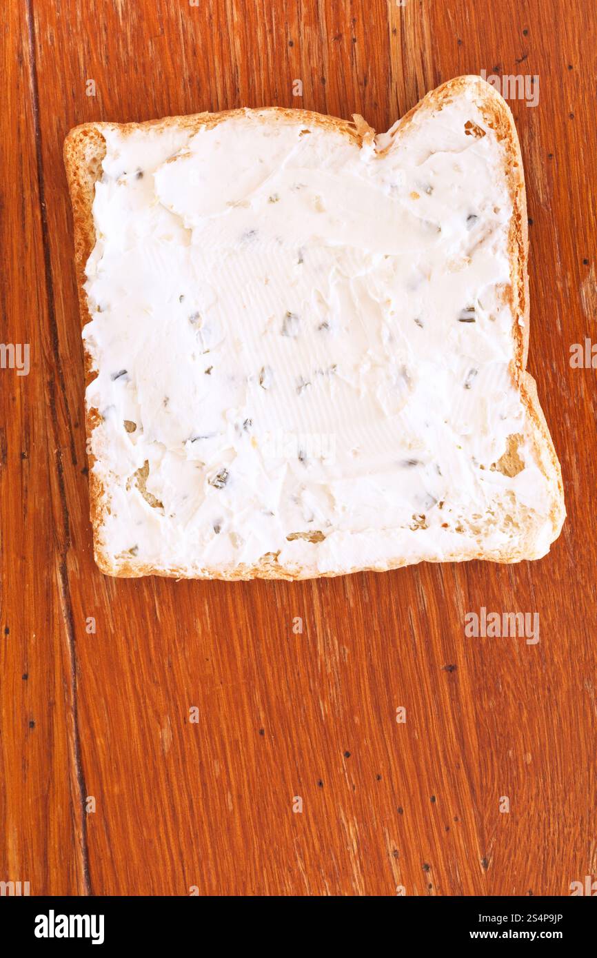 Sandwich de pain grillé et fromage aux herbes sur table en bois Banque D'Images