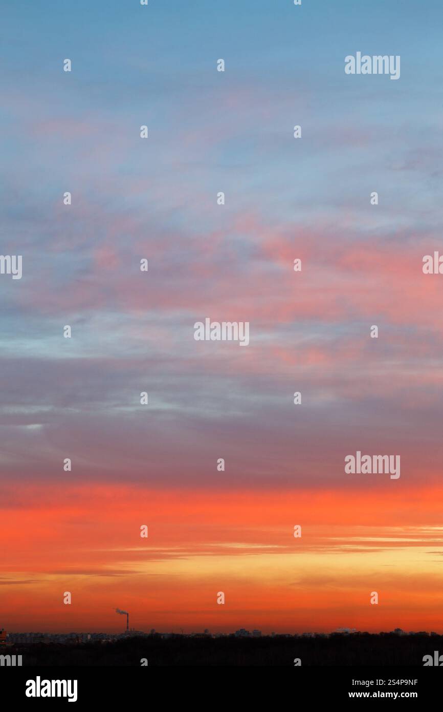 ciel au lever du soleil tôt avec des nuages bleus et roses au-dessus de la ville sombre Banque D'Images