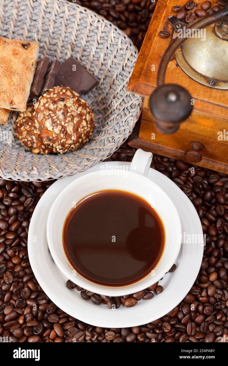 Vue supérieure de la tasse de café et de café torréfié avec moulin manuel en bois rétro, biscuits, barres de chocolat Banque D'Images