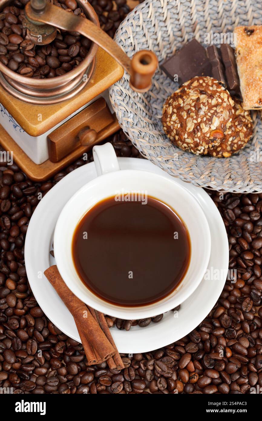 Vue supérieure de la tasse de café et de café torréfié avec retro manuel cuivre moulin, biscuits, chocolat, cannelle Banque D'Images