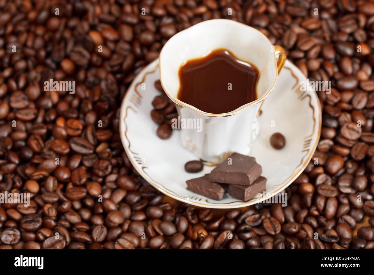 Au-dessus de la petite tasse de café et de café torréfié avec des barres de chocolat Banque D'Images