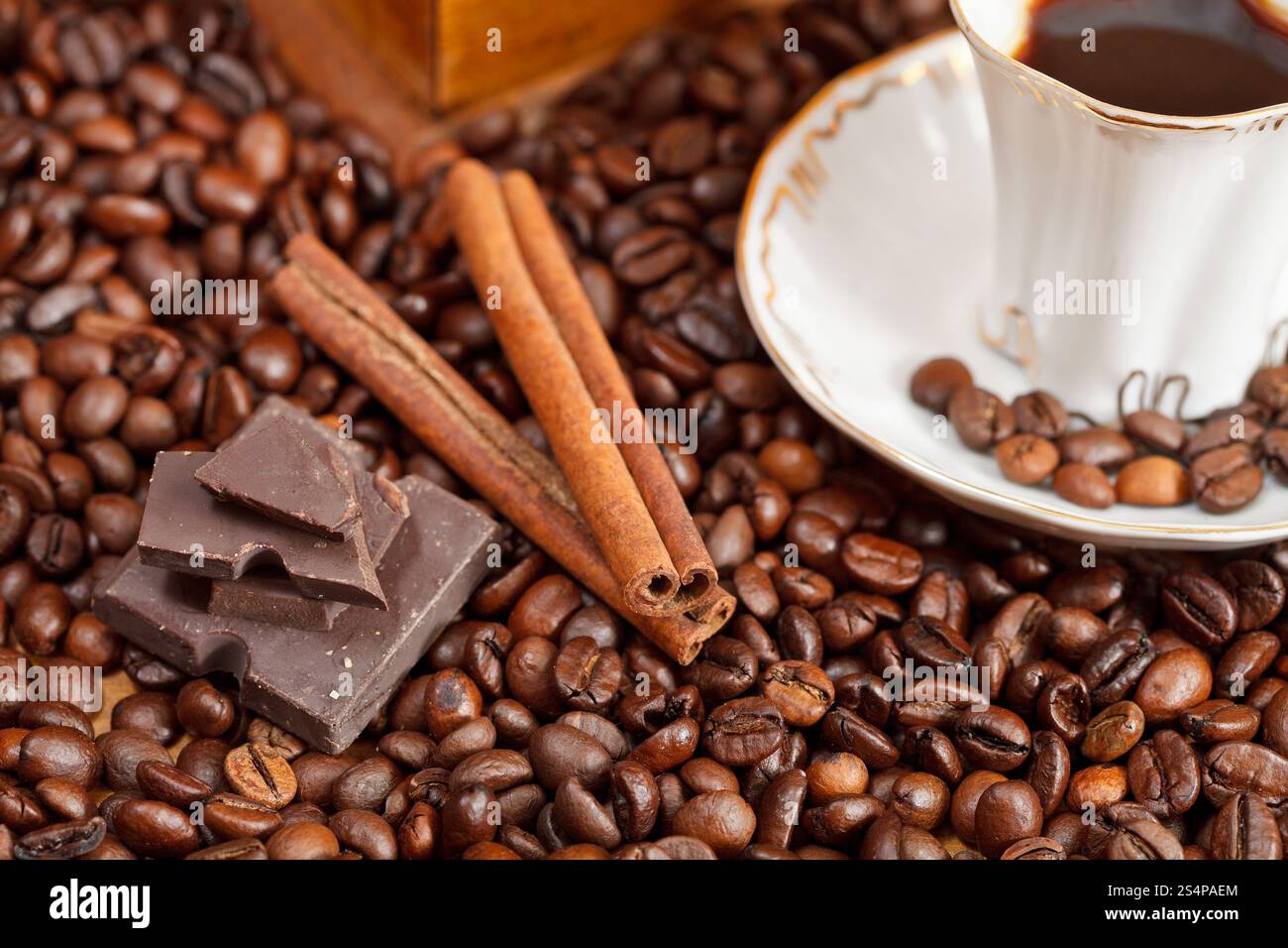 Petite tasse de café et de café torréfié avec moulin manuel en bois rétro, la cannelle, les barres de chocolat close up Banque D'Images