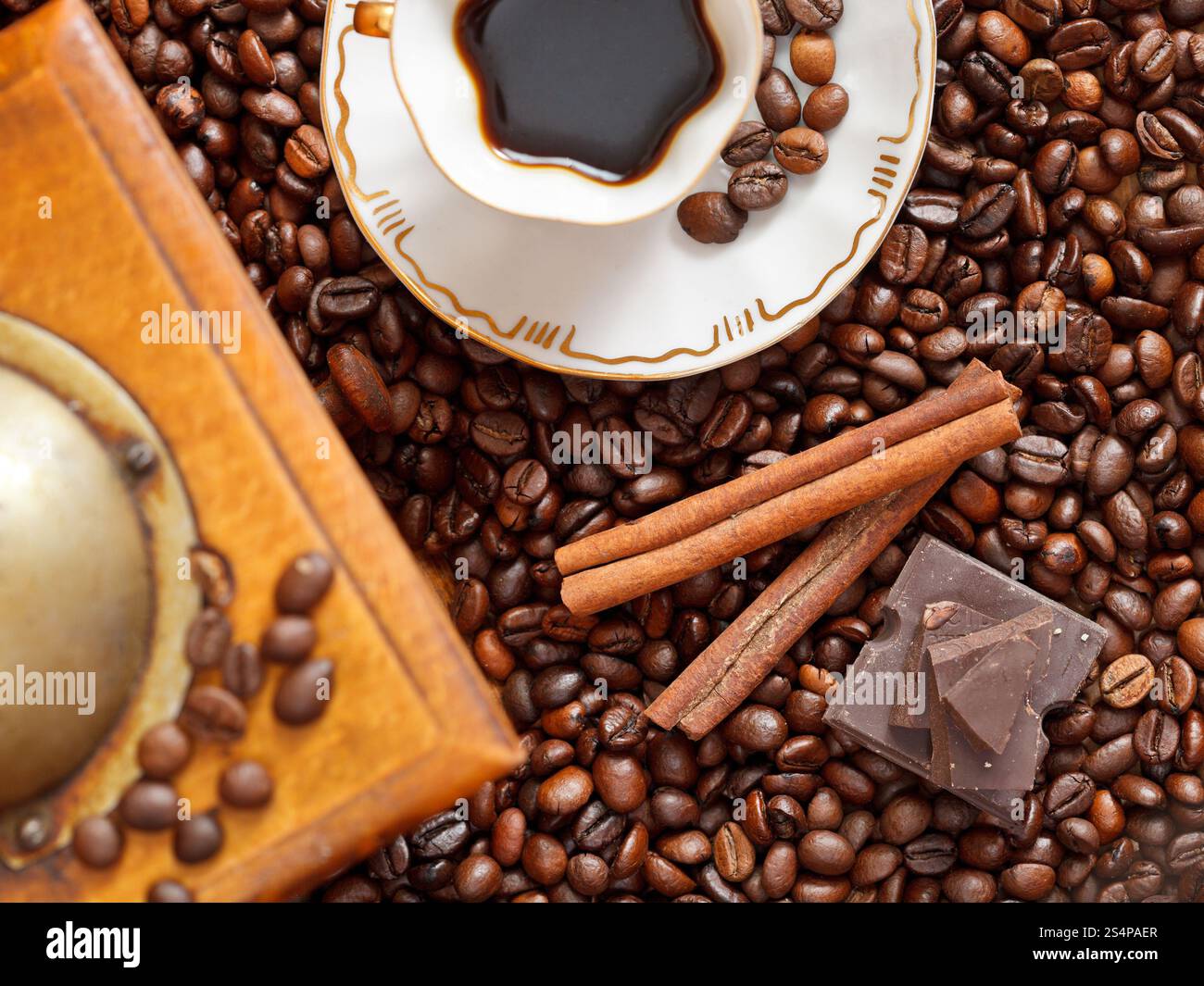 Vue supérieure de la petite tasse de café et de café torréfié avec moulin manuel en bois rétro, la cannelle, les barres de chocolat close up Banque D'Images