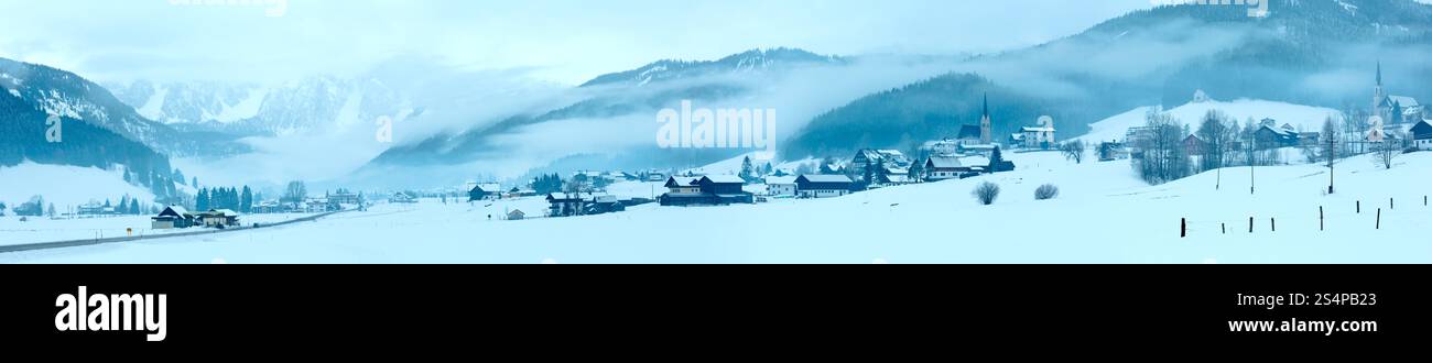 Village de montagne Hiver paysage brumeux avec des nuages bas (Autriche). Banque D'Images