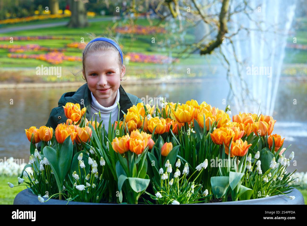 Happy girl et belles tulipes jaune-rouge. Spring Park. Banque D'Images