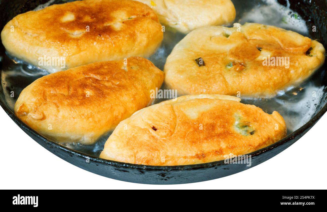 Galettes avec green oignon de printemps et les oeufs dans une poêle isolé sur fond blanc Banque D'Images