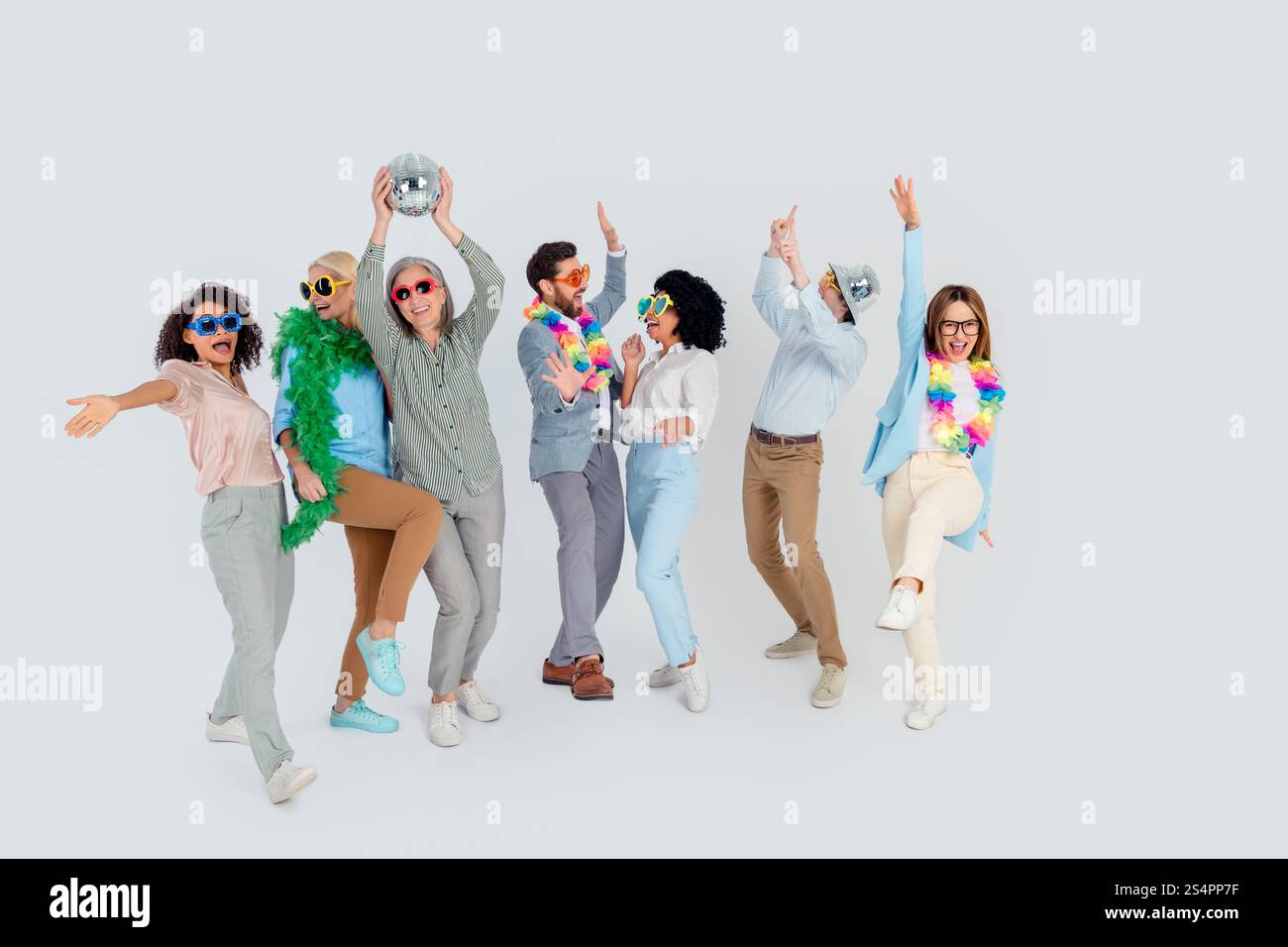 Groupe de collègues divers portant des tenues ludiques profitant d'une activité d'équipe sur un fond gris Banque D'Images
