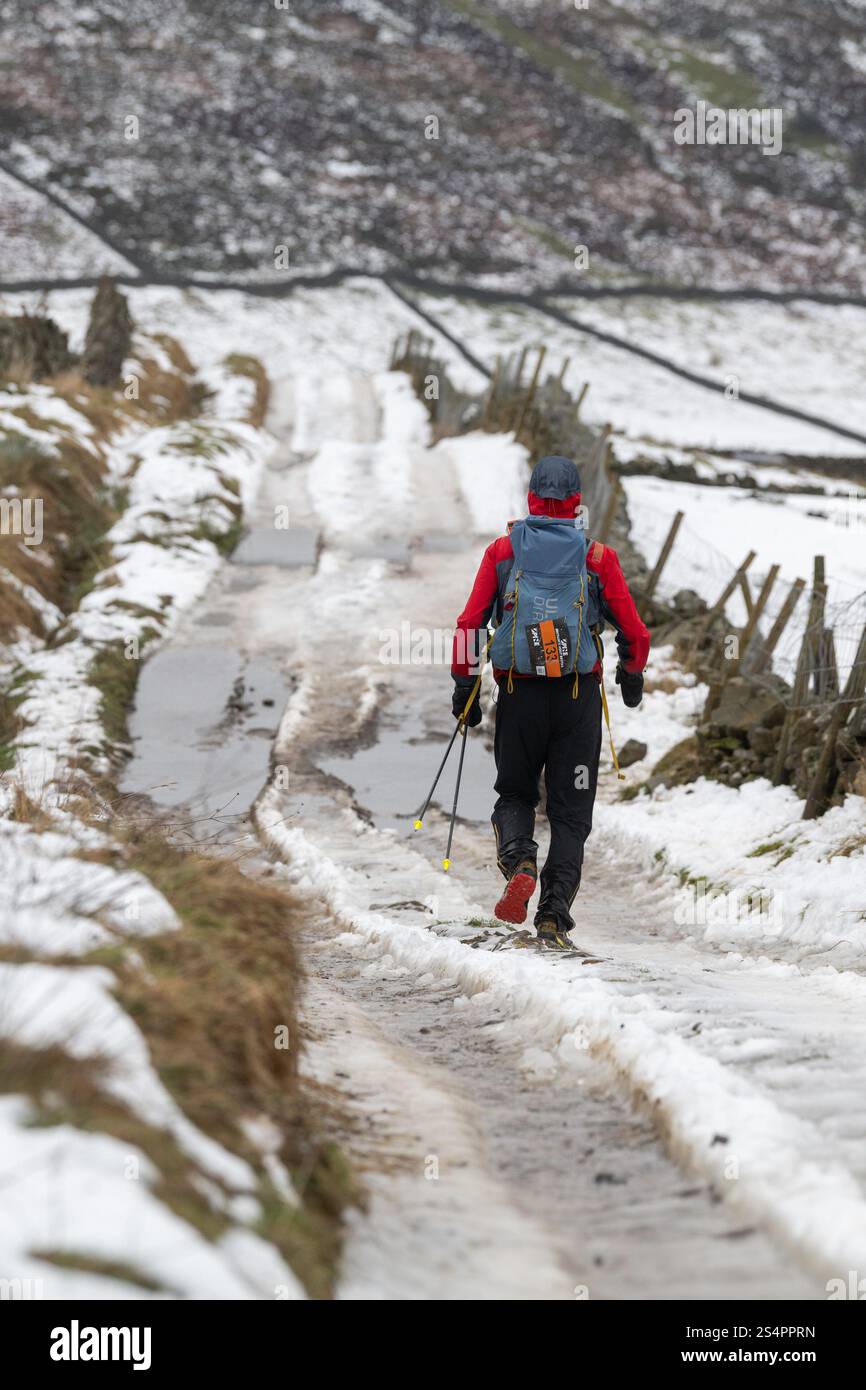 Thwaite, Swaledale, North Yorkshire. 13 janvier 2025. Kim Collison mène l'épuisante Montane Spine Race, une course brutale de 250 miles le long du sentier Pennine Way d'Edale dans le Derbyshire à Kirk Yetholm dans les Scottish Borders, en direction de Thwaite, Swaledale, environ 113 miles dans leur trek. Les conditions météorologiques ont été dramatiques, partant dans la neige, maintenant le dégel a pris place dans les pistes sont juste de la glace solide. Crédit : Wayne HUTCHINSON/Alamy Live News Banque D'Images