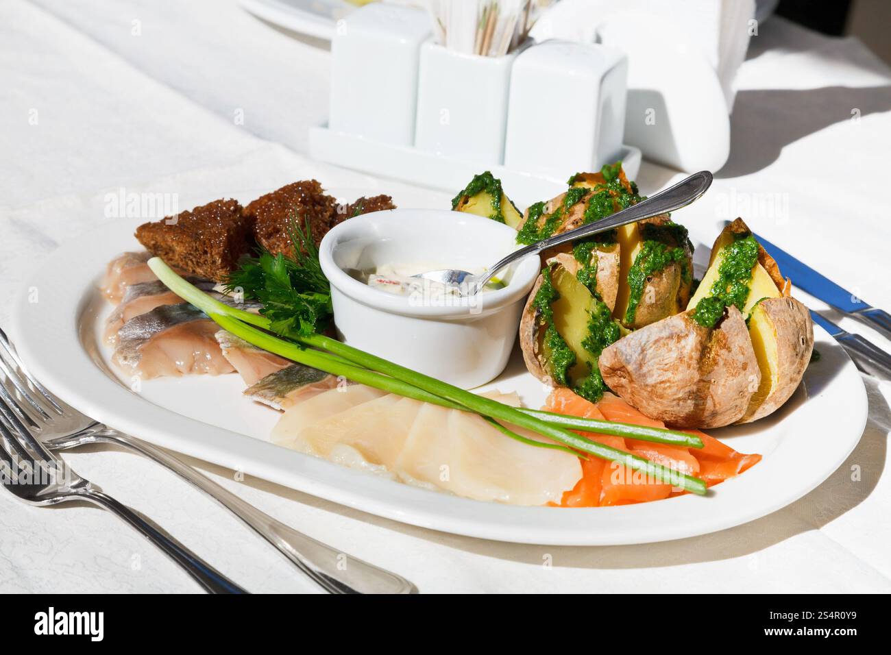 Entrée froide - assortiment de poisson salé avec pomme de terre au four sur plaque blanche at outdoor restaurant Banque D'Images