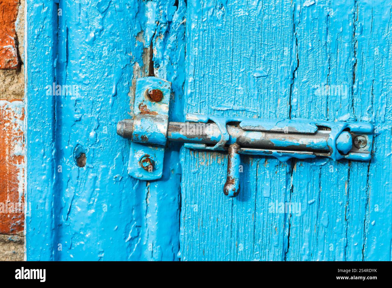 espagnolette minable sur la vieille porte peinte en bleu de près Banque D'Images