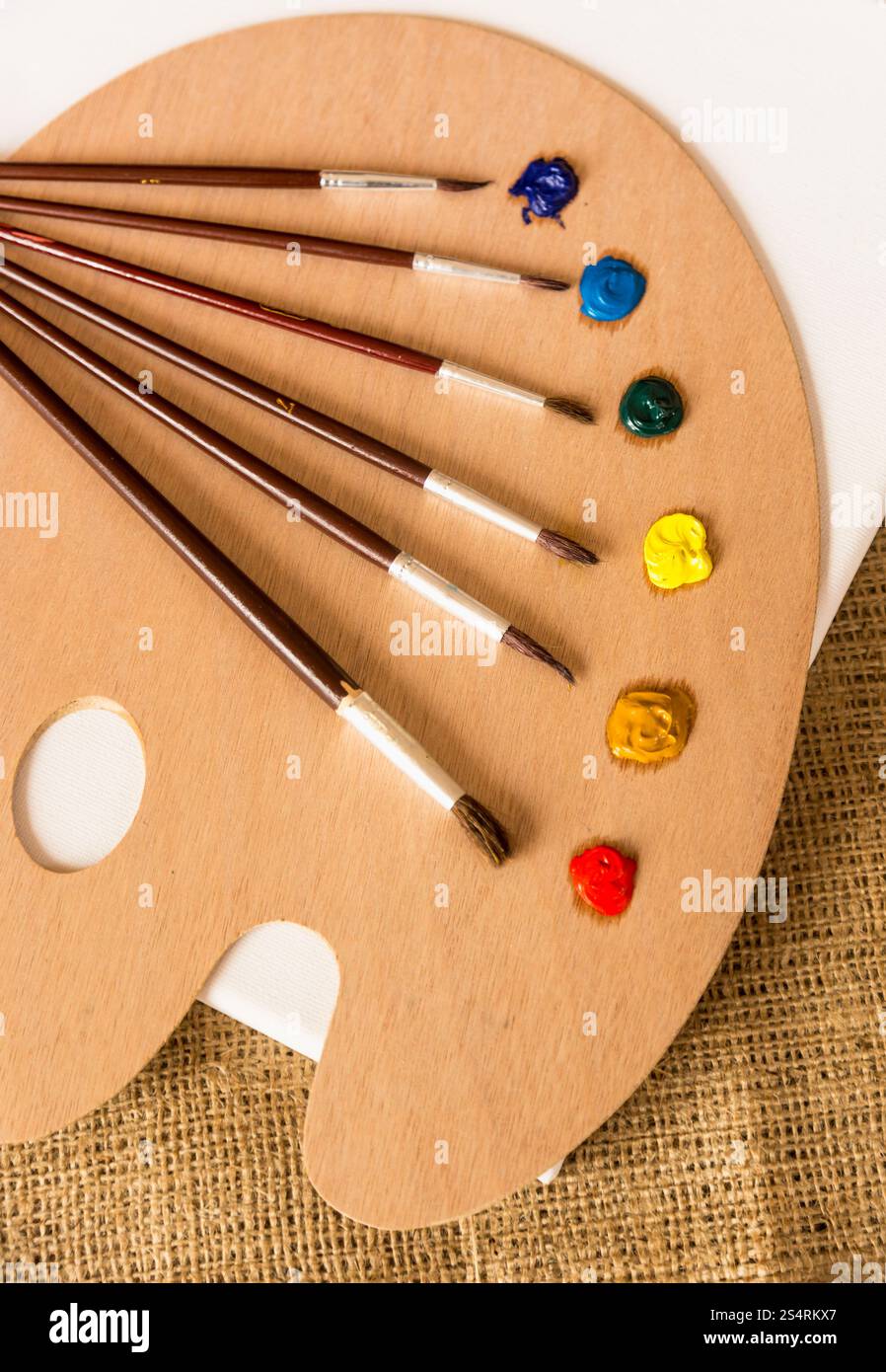 Photo gros plan de pinceaux professionnels couché sur palette en bois avec des peintures à l'huile Banque D'Images